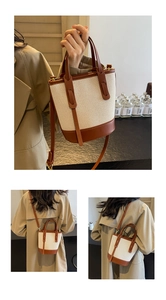 Detail view of contrast color bucket bag with canvas stitching and leather straps