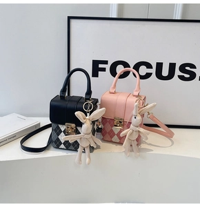 Détail de mini sacs bandoulière matelassés avec fermoirs dorés et charms lapin