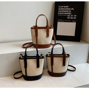 Three color-block canvas bucket bags with faux leather trim and adjustable straps