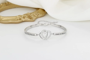 Detail of silver heart bracelet featuring crystal inlay and memorial engraved text