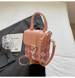 Détail du sac bandoulière matelassé rose et blanc avec fermoir en métal doré sur un blazer