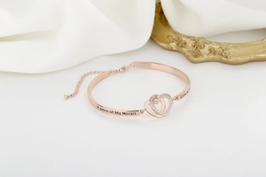 Detail of rose gold heart bracelet with sparkling stones and engraved tribute text