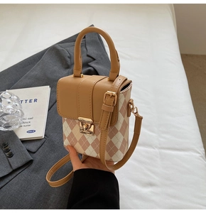 Détail d'un mini sac bandoulière matelassé kaki et rose avec fermoir rotatif doré
