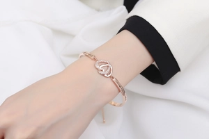 Detail view of rose gold heart bracelet with micro-paved zircons and engraved quote