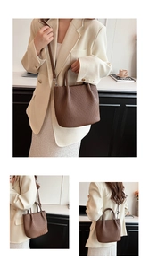 Detail showing the vertical pleated texture and leather craftsmanship of the dark brown bucket bag
