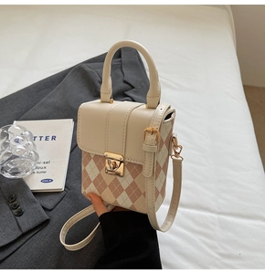 Détail du sac boîte matelassé chic avec serrure métallique et poignée en cuir rose tendre