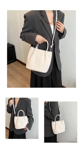Detail of cream pleated bucket bag with round handles and adjustable shoulder strap