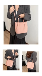 Detail of light pink bucket bag showing vertical pleated texture and round handle