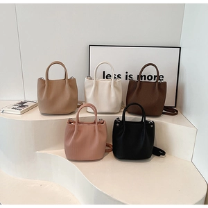 Detailed close-up of pleated texture bucket bags in various colors on display