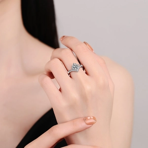 Elegant V-shaped crown moissanite ring with silver band displayed on a finger