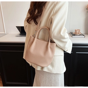 Pink pleated bucket bag shown in a professional lifestyle setting with silver hardware