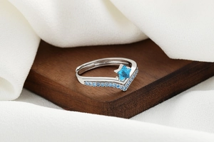 Macro shot of silver-tone open ring with blue star gemstone and micro-pave detailing