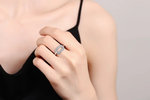 Detailed close-up of a silver open ring with micro-paved zircons worn on a finger