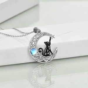 Close-up of Celtic moon necklace with black cat and blue gemstone on white pedestal