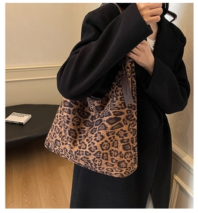 Detail view of large leopard print tote bag styled with a minimalist black wool coat