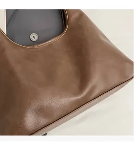Close-up of deep brown leather tote bag texture and white CHERIMATE branding detail