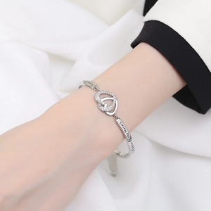 Silver interlocking hearts bangle with sparkling zircons and emotional engraving