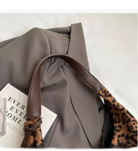 Detail of leopard print tote bag with durable dark brown lychee leather shoulder straps