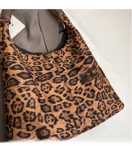 Detail of leopard print tote bag featuring soft suede texture and dark brown leather strap