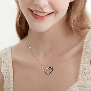 Collier cœur ailé en or rose avec zircons noirs et blancs sur chaîne élégante