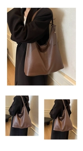 Detail of dark brown tote bag with pebble leather texture and vertical stitching
