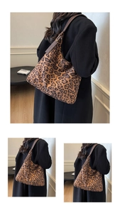 Detail of leopard print tote bag featuring brown leather shoulder straps and soft texture