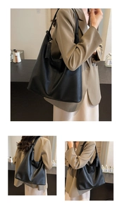 Detail of black lychee grain leather tote bag with wide strap and spacious hobo design