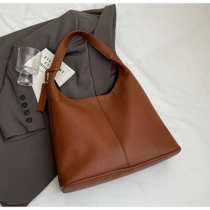 Close-up of deep brown lychee grain leather tote bag with vertical stitching detail