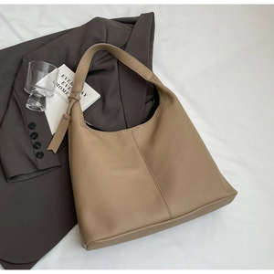 Detail of khaki pebbled leather tote bag with thick strap and minimalist design