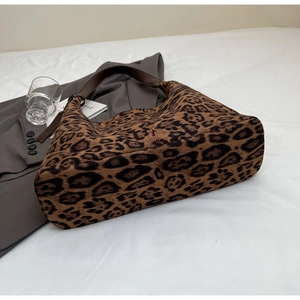 Macro detail of leopard print tote bag with brown leather handles and large capacity
