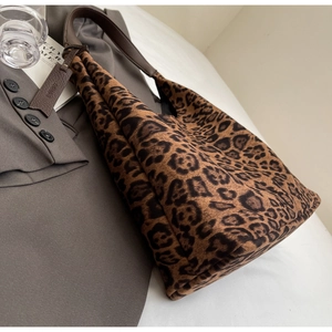 Close-up of leopard print hobo bag with suede texture and brown leather strap details