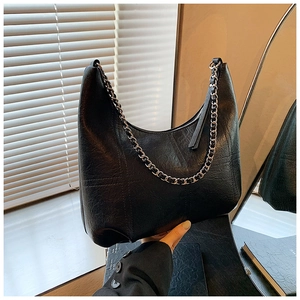 Detail of black vintage hobo bag with quilted leather texture and silver chain strap
