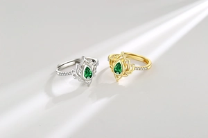 Dettaglio di anelli di loto in oro e argento con zircone verde a goccia e micro-intarsio