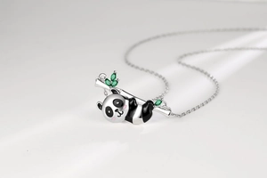 Detail of silver panda necklace with green gemstone bamboo leaves and enamel finish