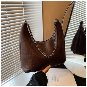 Detailed close-up of textured leather Hobo bag with woven metal chain in dark brown