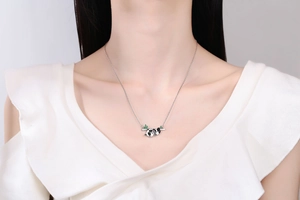 Close-up of a panda panda pendant on a bamboo branch necklace worn by a female model