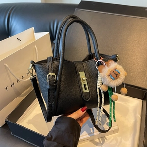 Chic black litchi pattern bucket bag with golden lock and cute lion plush charm