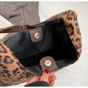 Interior detail of leopard print tote bag with brown leather handles and magnetic closure