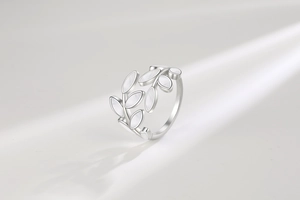 Detailed macro view of leaf shaped ring with pearl texture inlay on a grey background