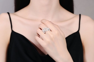 Detailed view of leaf-shaped silver ring with white enamel on woman's finger
