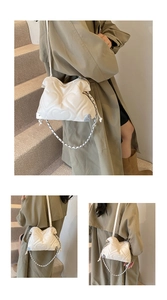 Détail du sac seau blanc matelassé cœur avec coins métalliques et bandoulière chaîne