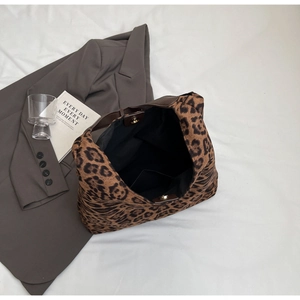 Detail of leopard print tote bag with magnetic snap closure and black interior lining