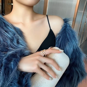 Close-up of adjustable gold leaf ring worn by a model in a luxury evening fashion setting