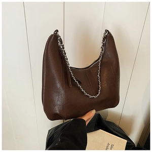 Detail view of dark coffee vintage shoulder bag with cross stitching and silver metal chain