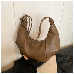 Detailed view of the pleated coffee brown croissant bag in textured PU leather