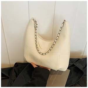 Detail of cream hobo bag showing litchi texture and metal chain shoulder strap