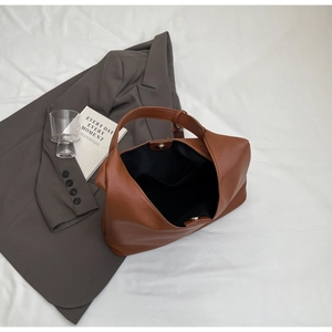 Detailed top view of brown pebble leather tote bag with magnetic closure and inner pocket