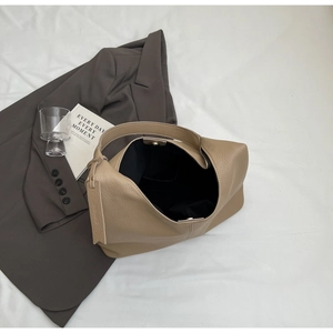 Macro detail of beige pebble grain leather tote bag with soft texture and spacious interior