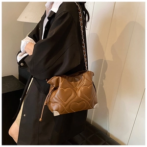 Détail du sac seau marron plissé avec matelassage en cœur et coins renforcés en métal