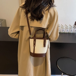 Minimalist canvas and leather bucket bag with contrast trim and adjustable strap